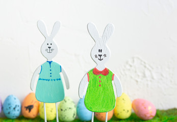 Wooden toy rabbits with colored Easter eggs.