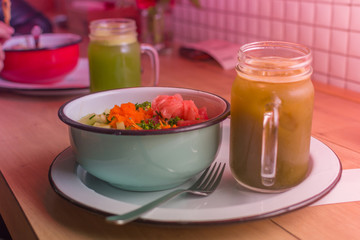 Healthy raw food clean eating selection: salmon, vegetable and fruits in a bowl with a green beverage in a glass jar. Raw diet