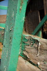 Close Up of Weathered Fence Post with Peeling Paint and Spiderweb