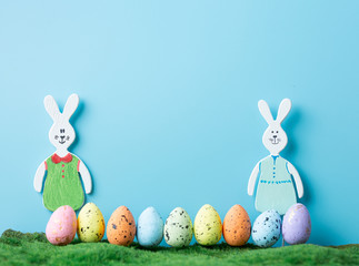 Wooden toy rabbits with colored Easter eggs.