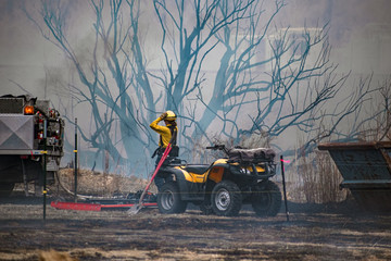 Female Firefighter Pulls Hose and Rides an ATV at a Wildfire