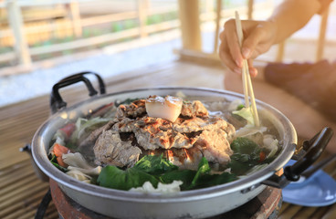 hand chopstick picking meat grilled for eating 