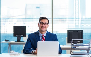 Young handsome businessman employee working in office at desk