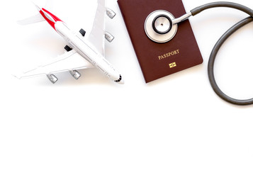Medical stethoscope, passport and airplane model isolated on white background with copy space....
