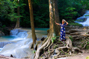 Woman stand look waterfall  at Erawan Waterfall and  natural