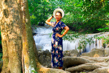 Woman stand at tree on waterfall  at Erawan Waterfall