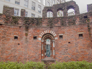 Fototapeta premium ruin of a 13th century Romanesque church apse in a flowerbed in Missori square. Milan - Italy