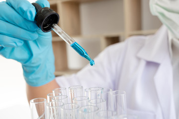 Medical scientists released a sample pipette into a test tube to analyze the virus in a chemical...