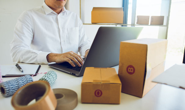 Entrepreneurs are working on taking orders of customers products by typing information tpying keyboard laptop computer in office room.
