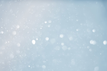 Abstract bokeh sparkle on light blue background