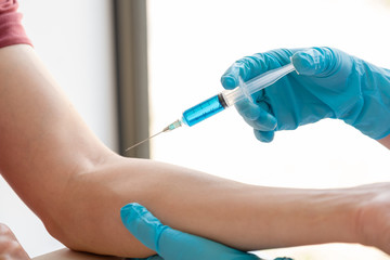 Female doctors vaccinated with syringes to prevent epidemics at hospitals, health care and medical concepts