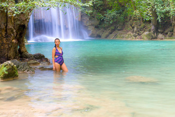 Woman with swimsuit stand relax at Erawan Waterfall