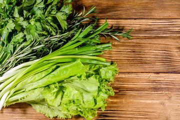 Lettuce rosemary and parsley on a wooden table. Vegan food. Top view