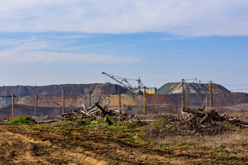 View on slag heaps of the iron ore quarry and heavy excavator