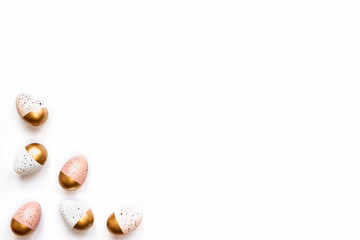 Top view of Easter eggs colored with golden paint. Various colorful designs. White background.