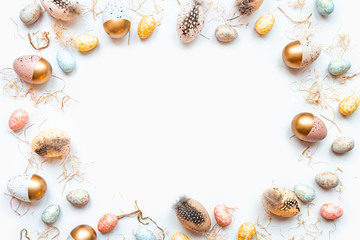 Top view of Easter eggs colored with golden paint in different patterns. White background. Copy space.