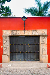 Carved wooden door in colonial house of La Antigua Guatemala, exterior detail shows security and private property, access to home.