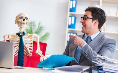 Businessman working with skeleton in office