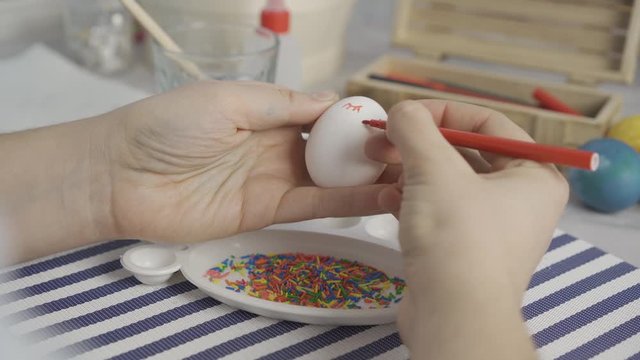 painting eggs at home. preparation for Easter. the tradition of drawing. paint and glitter on colored eggs