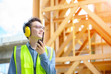 Young asian engineers are working on the construction site. Wear a yellow earmuff sound protection...