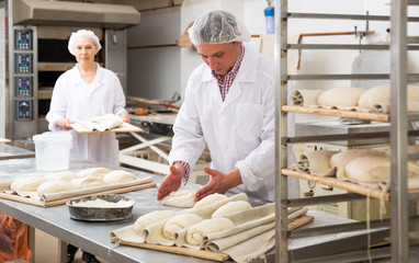 Portrait of experienced professional baker during daily work in kitchen of small bakeshop