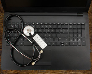 Laptop phonendoscope pill black keyboard. The concept of digitalization in medicine