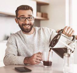 attractive man pouring himself a Cup of morning coffee