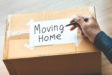 Moving home,house concepts with hand person writing text on brown box