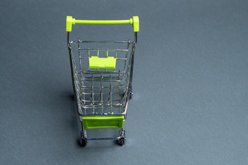 Toy shopping trolley on a gray background, close-up. Copy space