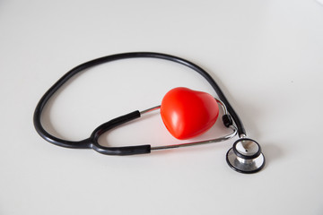 Stethoscope doctors and red heart cardiology placed on a white table in the hospital, concept:...