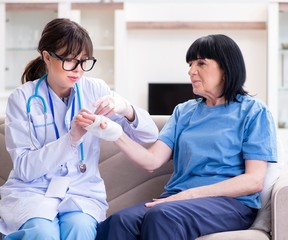 Fototapeta premium Doctor examining old mature woman after incident