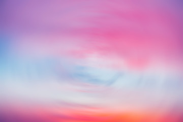 Beautiful backdrop of sunset sky with pink orange light clouds in blue sky. Colorful smooth dawn sky gradient. Nature background of sunrise. Amazing morning heaven. Slightly cloudy evening atmosphere.