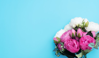 Pink and white flowers on blue background. Mother’s Day, Spring concept. Greeting, invitation card. Flat lay, top view style with copy space for your text.