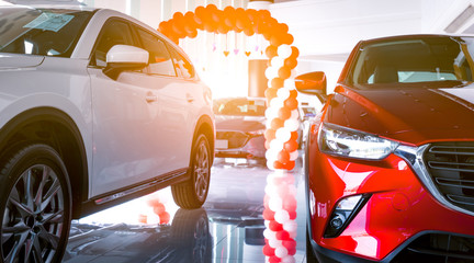 Front view of red and white SUV car. New and shiny luxury SUV car parked in modern showroom for...