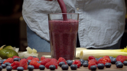 Woman pouring smoothies into the glass