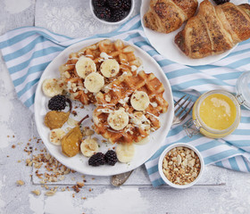 Belgian waffles with syrup, berries and honey, breakfast on a light background, Selective focus