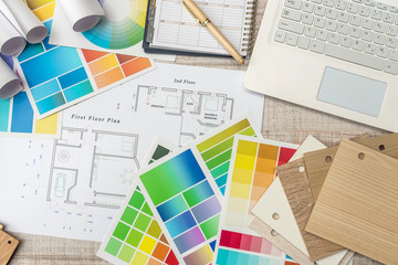 architectural blueprints with paper and wooden color sampler on creative desk