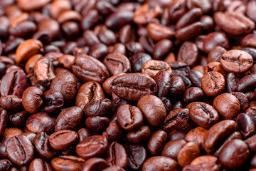 Grains of fresh roasted coffee close-up against a dark background