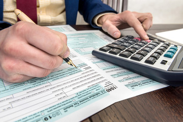 Accountant fills in tax form. Businessman accounting finance document. Paperwork, time for tax.