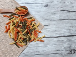 Three colored of Fusilli pasta on sack background