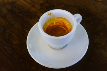 A white Cup of Espresso cup on wooden table wood background.