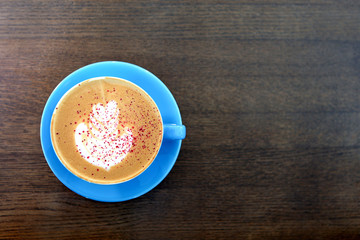 Big Coffee cup with milk on the wooden table. cappuccino or latte drink, cup of coffee on brown table flat lay view. Cup of cafe au lait. Milk paintings. Hot Coffee in a blue mug