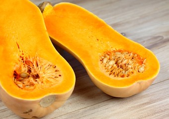 Pumpkin Butternut Liscia cut in half.   Yellow delicious pumpkin on wooden table.