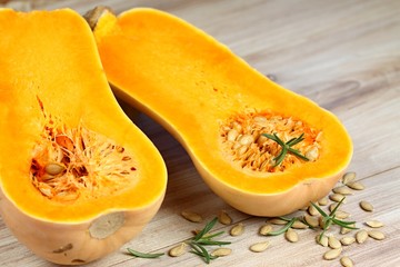 Pumpkin Butternut Liscia cut in half.   Yellow delicious pumpkin on wooden table.