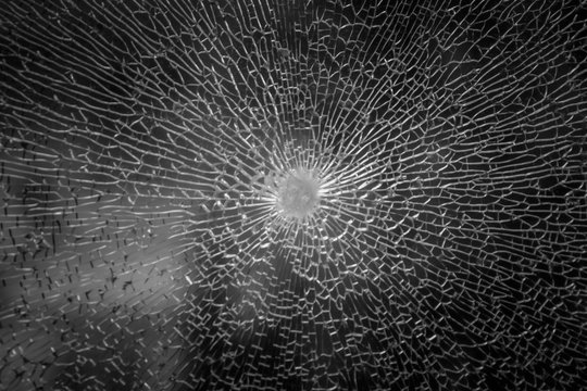 Cracks in the glass on the black background or Bullet hole. Isolated realistic cracked effect, Cracked black concept. Abstract broken glass texture on a black background on window car transparent.