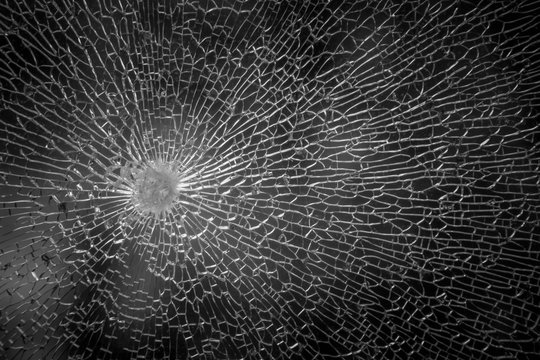 Cracks In The Glass On The Black Background Or Bullet Hole. Isolated Realistic Cracked Effect, Cracked Black Concept. Abstract Broken Glass Texture On A Black Background On Window Car Transparent.