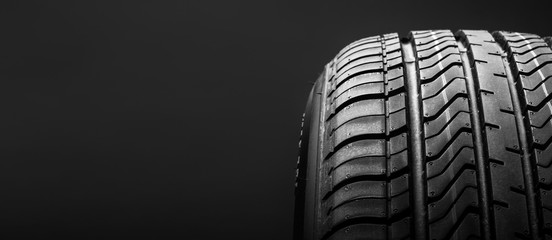 a black isolation rubber tire, on the black backgrounds - obrazy, fototapety, plakaty