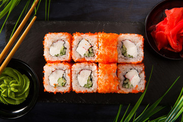 Set of sushi rolls with wasabi and ginger on a black background. Japanese oriental cuisine