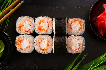 Set of sushi rolls with wasabi and ginger on a black background. Japanese oriental cuisine