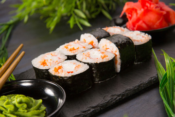 Set of sushi rolls with wasabi and ginger on a black background. Japanese oriental cuisine